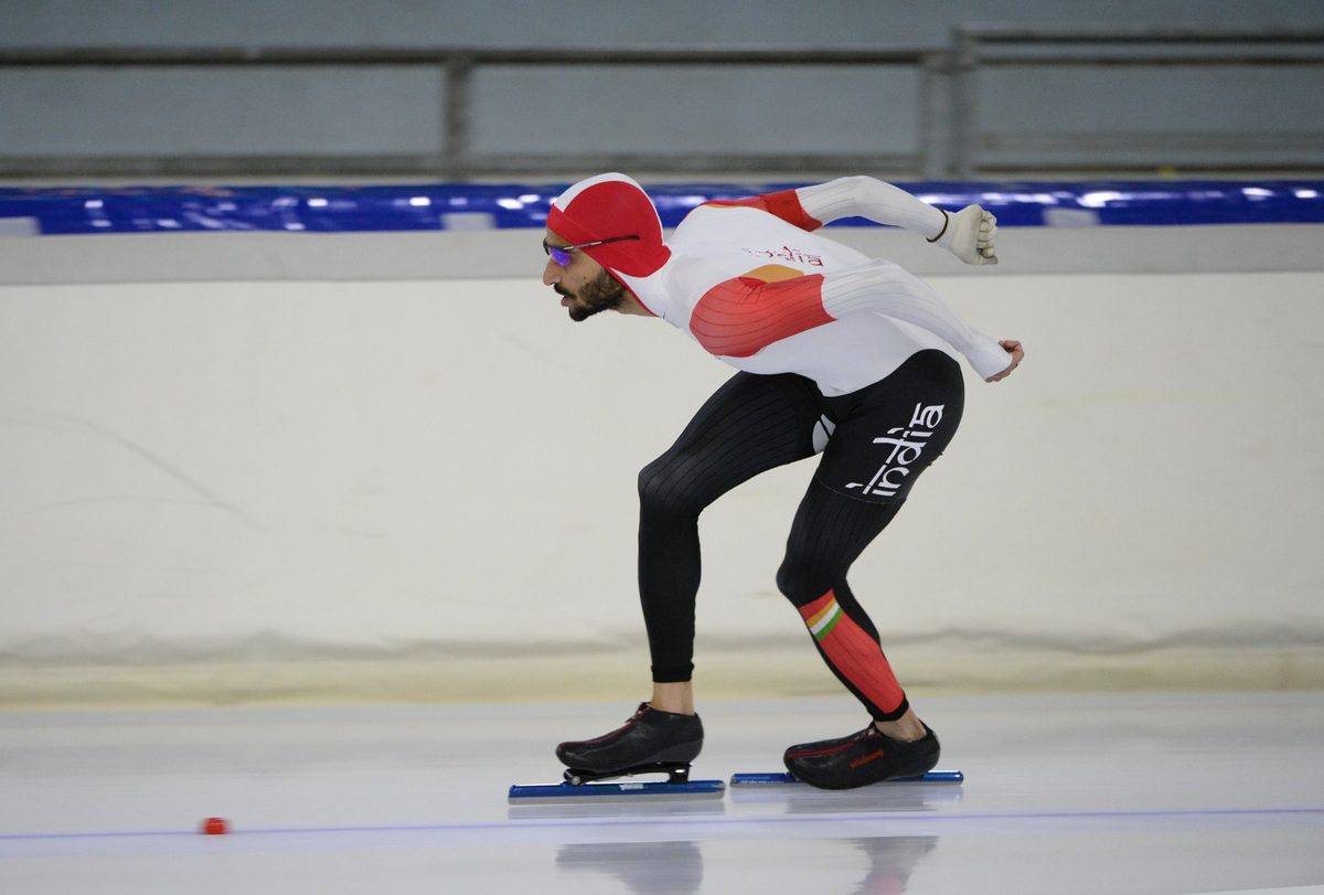 Vishwaraj in full tuck on an indoor long-track oval, India suit